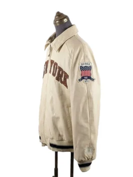 Three-quarter angle view of a collared streetwear jacket on a mannequin, showcasing arched chest lettering and a shield patch on the upper sleeve.
