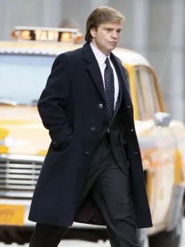 Sebastian Stan Donald Trump trench coat in black wool, walking past a yellow taxi cab.