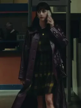 Scodelario Leather Coat The Gentlemen 2024 leather outfit showing a long purple trench coat over a plaid dress. Kaya Scodelario belted leather coat The Gentlemen.