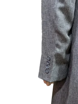Theo James as Eddie Halstead wearing a sophisticated gray suiting fabric trench coat in a scene from The Gentlemen 2024.