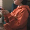 A trendy Orange Slogan Hoodie as seen on Lily Collins in the hit series.