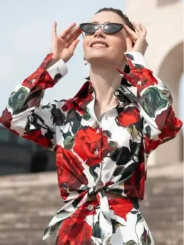 Lily Collins as Emily Cooper in Emily in Paris Season 5 wearing a vibrant rose print long-sleeve shirt.