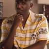 Samuel Arnold wearing a Yellow Striped Shirt with a crisp white collar in Emily in Paris S05.