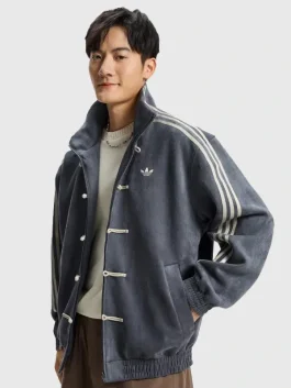 2026 Chinese New Year grey tang suede jacket with traditional knot buttons and athletic three-stripe sleeves.