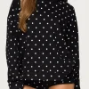 Front view of black Chelsie polka dot hoodie. Viral 2026 streetwear style with white spots and oversized fit.