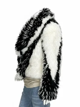 two-tone jacket with thick white and black multi-textured panels worn over a beige top and jeans.