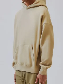 Side view of the Fear Of God Essentials Pullover Hoodie showing the dropped shoulders.