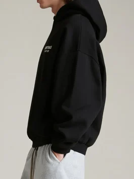 The Essentials Black Fleece Hoodie with a modern oversized fit.