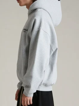 Left side view of the Essentials Light Heather Grey Hoodie showing the sleeve fit.