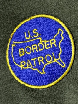 Close-up of a green wool coat highlighting the lapel style collar, button front, and full-length sleeves.