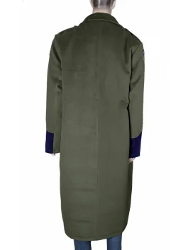 Detailed shot of the Greg Bovino coat's shoulder patch and gold button detailing against the dark green wool fabric.