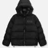 A heavy, black quilted puffer jacket featuring a large hood and a subtle, tonal "RTA" logo printed on the left chest.