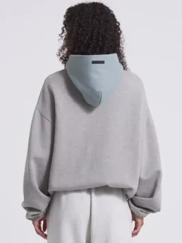 The back view of a New York Liberty Fear Of God Essentials Hoodie showing the athletic drape and hood.