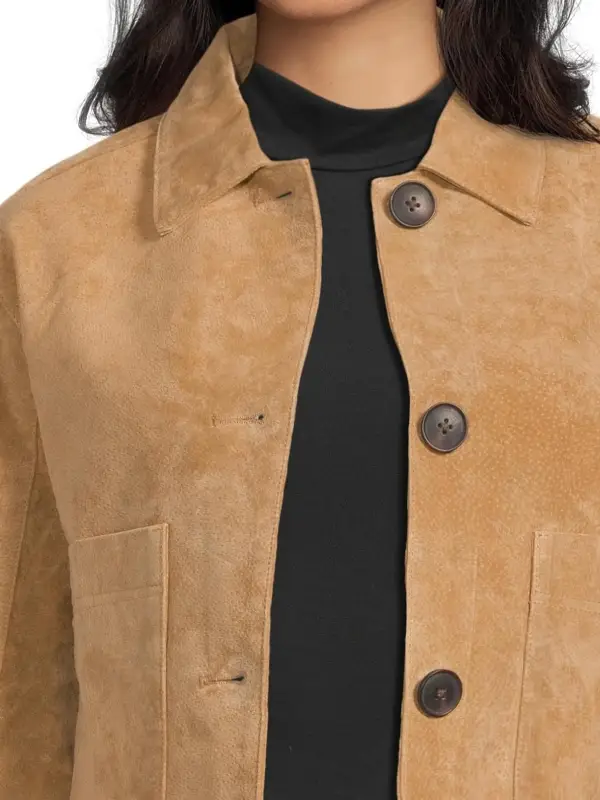 Close-up detail of the shirt style collar and soft suede leather texture on a brown women's jacket.