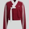 A stylish BABYMONSTER × Adidas Hanbok Fusion Jacket designed with a sleek wrap style tie and full length sleeves.