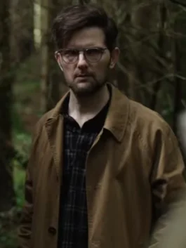 Side view of the custom recreation Hokum 2026 Adam Scott brown coat in a rustic indoor setting.