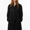 Eva Stratt long black trench coat with refined cinematic outerwear appeal.