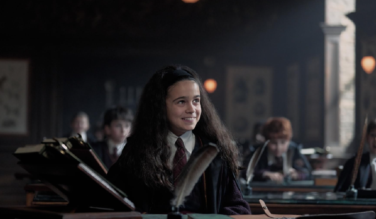 Arabella Stanton as Hermione Granger in a Hogwarts classroom in the Harry Potter TV series 2026 — dark academia style school uniform