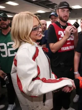 Sydney Sweeney wearing white leather NASCAR jacket during event appearance with red stripe details