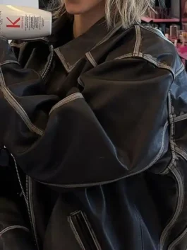 Close-up of Sydney Sweeney oversized brown leather jacket with contrast stitching and oversized sleeve detail