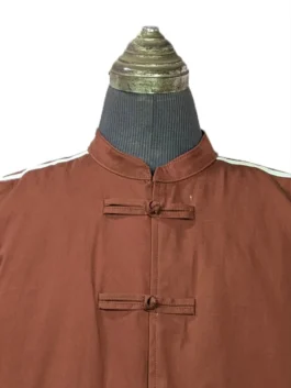 Detailed close-up of the Mandarin collar and top fabric frog closures on the brown Adidas CLOT Edison Chen track jacket.