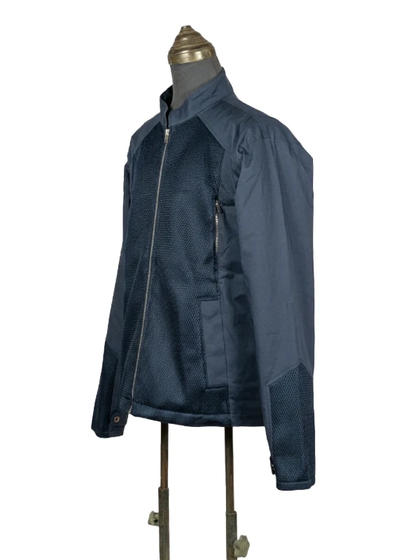 Three-quarter side angle display of the navy blue Captain America Steve Rogers jacket on a mannequin, emphasizing the fabric and mesh panel contrasts.
