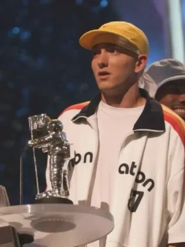 Eminem on stage holding an MTV VMA award, wearing the white PnB Nation jacket with 