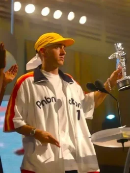 Eminem accepting an award in a white PnB Nation oversized track jacket with distinctive colorful sleeve detailing.