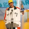Frontal view of Eminem at a podium in the PnB Nation white jacket, highlighting the oversized hip-hop fit.