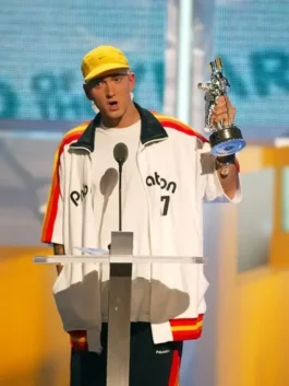 Frontal view of Eminem at a podium in the PnB Nation white jacket, highlighting the oversized hip-hop fit.