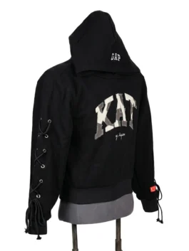 Left profile view of a streetwear fleece hoodie showing the metallic eyelet lacing system down the sleeve and rectangular flag patches.