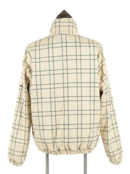 Rear view of the cream and green grid windowpane check pattern side of the Masters reversible quarter-zip jacket displayed on a dress form.
