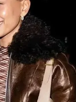 Brown leather jacket with fur trim and modern celebrity street style.
