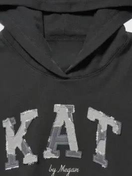 Gap x Katseye Megan Hoodie front view in black fleece with a soft pullover look and relaxed hooded shape