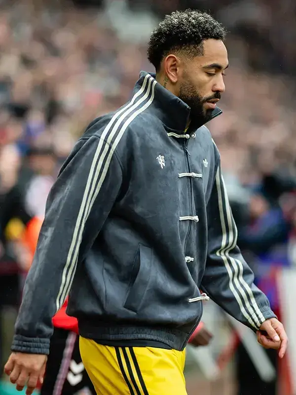 Close-up of grey Adidas CNY jacket showing knot button closure, side pockets, Adidas Trefoil and Man United crest clearly
