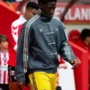 Manchester United player wearing grey Adidas CNY jacket and yellow Man United shorts during Matchday 36 Premier League walkout