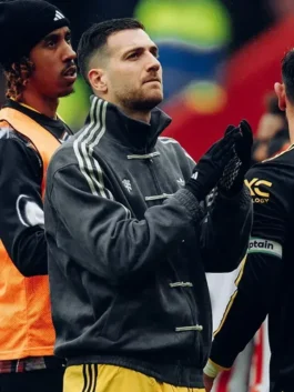 Manchester United player wearing grey Adidas CNY jacket during warm-up alongside orange-bibbed teammates at the stadium