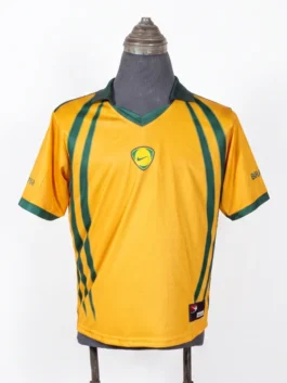 Full-length front presentation of the yellow CJ x Nike Total 90 Retro Brasil Jersey displayed on a mannequin against a white background.