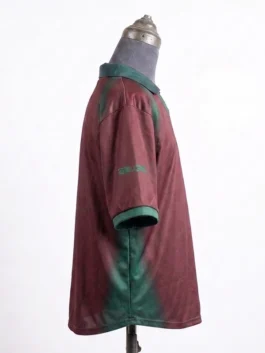 Side view of the maroon CJ x Nike Portugal Total 90 Retro Jersey on a mannequin, displaying dark green airbrush detailing under the arm and graphics on the sleeve.