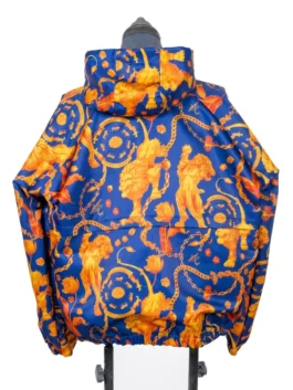 Rear-facing product image of the hooded Netherlands Anthem Jacket on a display stand, showcasing the symmetrical, repeating orange royal chain and lion graphics running along the back panels and hood.