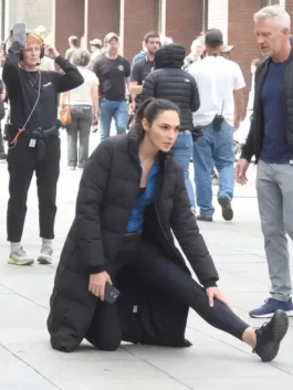 Front profile of the black parachute Gal Gadot The Runner Puffer Coat highlighting full length sleeves and long quilted panels.