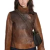 Close-up front profile of the brown leather The Bride Premiere Mia Regan Leather Jacket detailing the loop button closure and stand up collar.