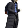 Full-length profile view of the black parachute Gal Gadot The Runner Puffer Coat showing its long silhouette and full sleeves.