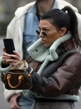 Brown real leather Kourtney Kardashian Shearling Leather Jacket highlighting the stand up collar and front zip closure.